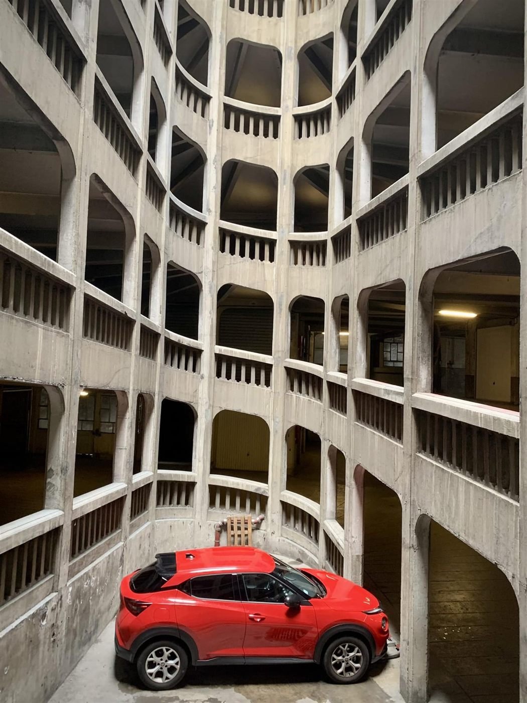 Rampes de béton en spirale, une voiture rouge au premier plan