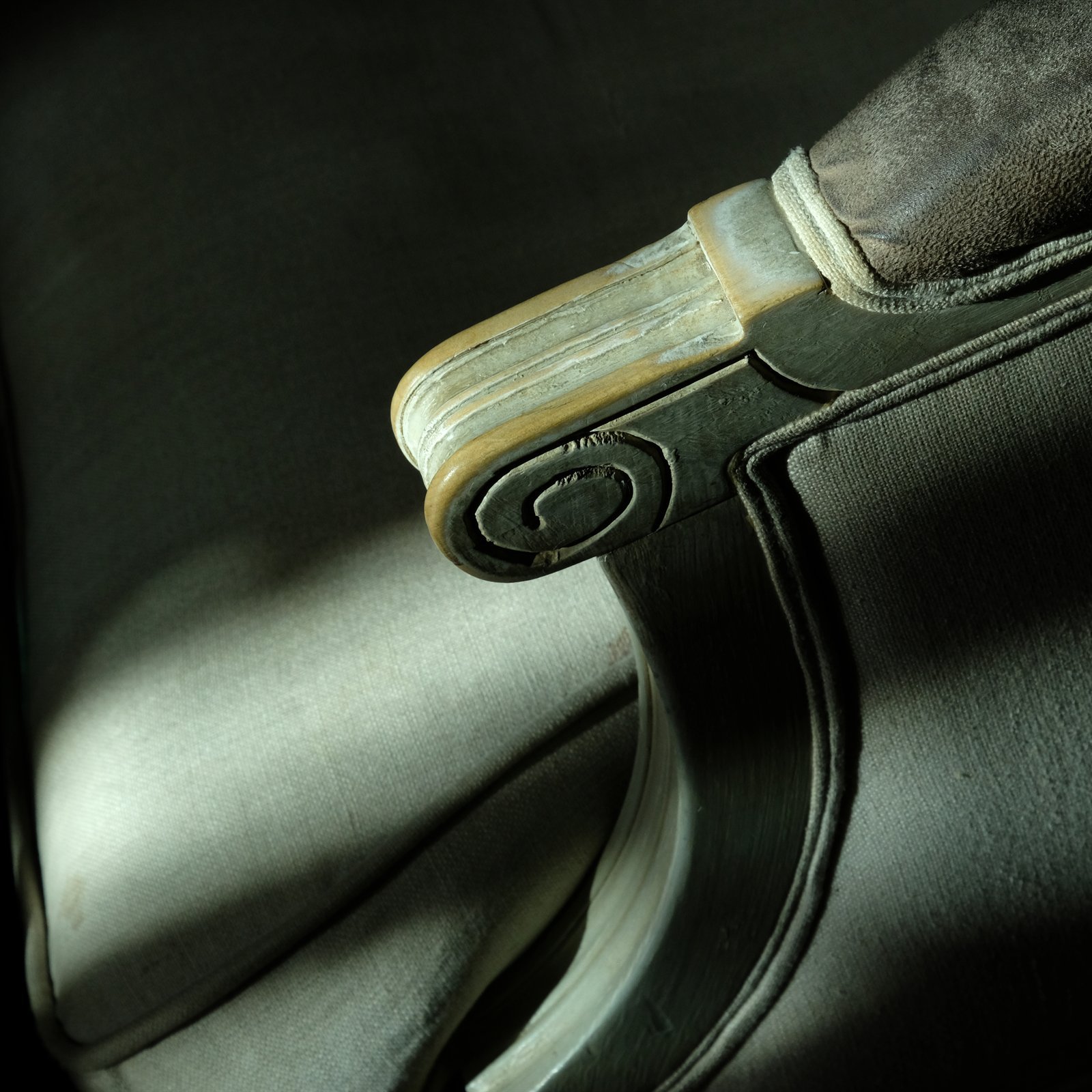 Accoudoir sculpté d'un fauteuil, éclairé de côté