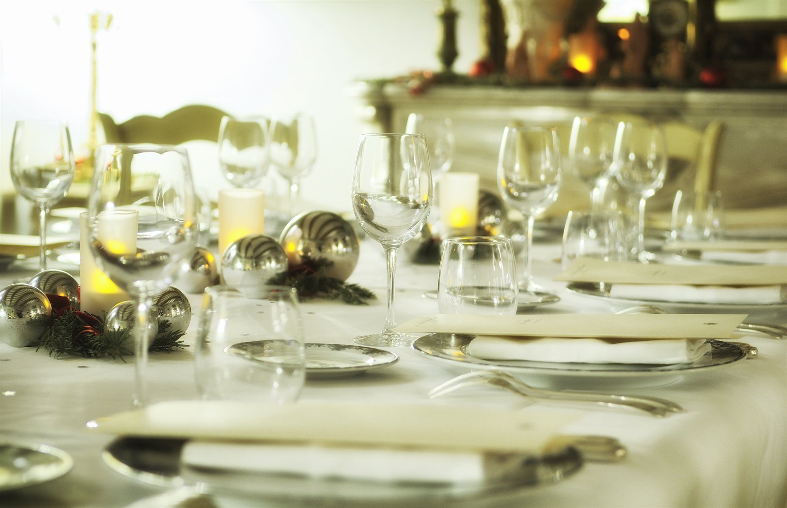 Table de fête dressée, verres et bougies dans une lumière dorée