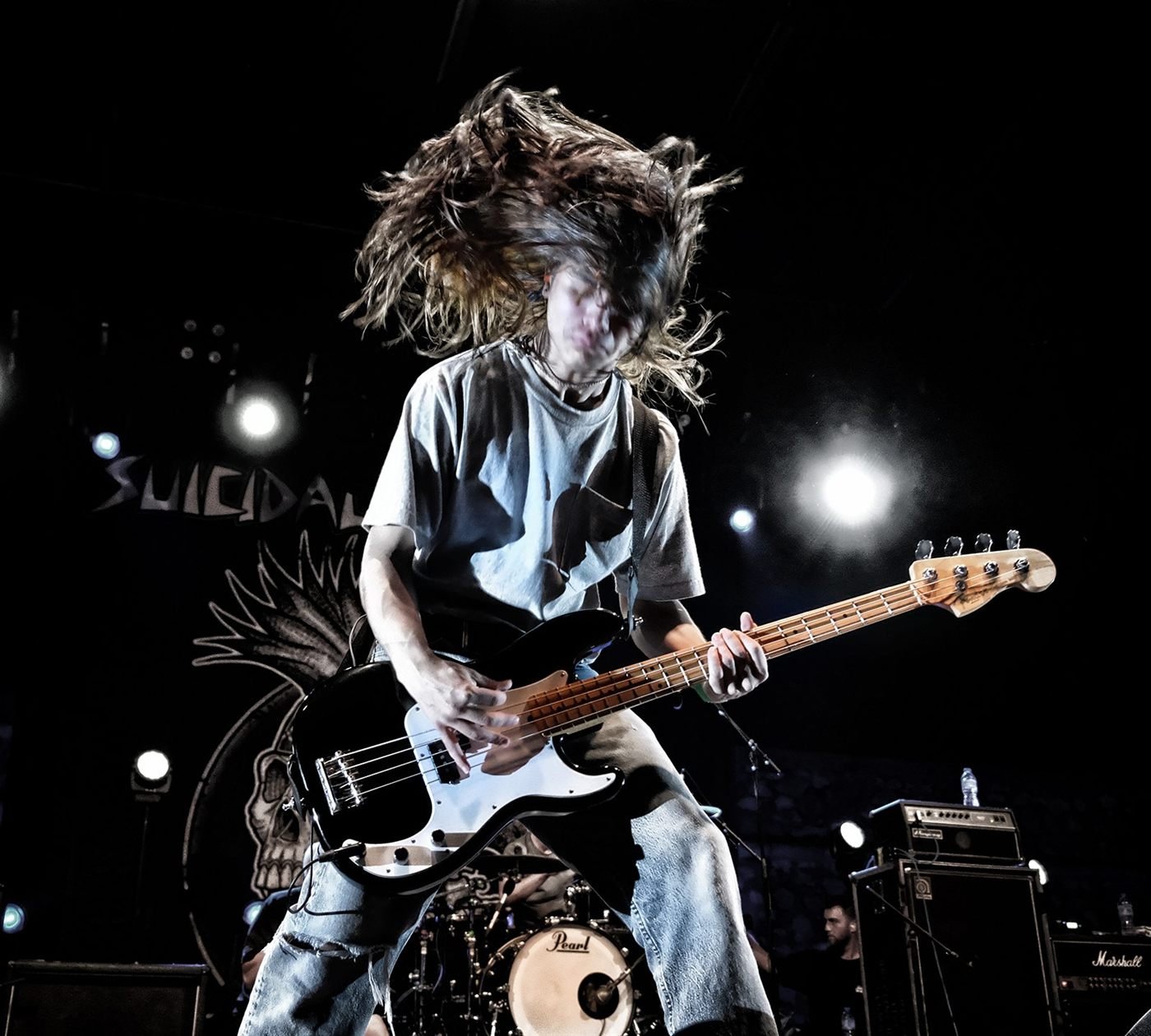 Bassiste en plein mouvement, cheveux au vent