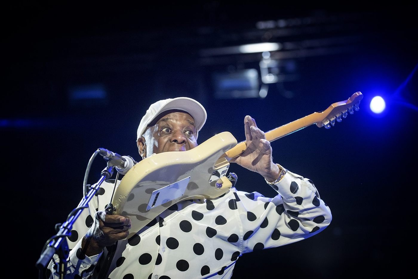 Buddy Guy en concert, chemise à pois, guitare levée