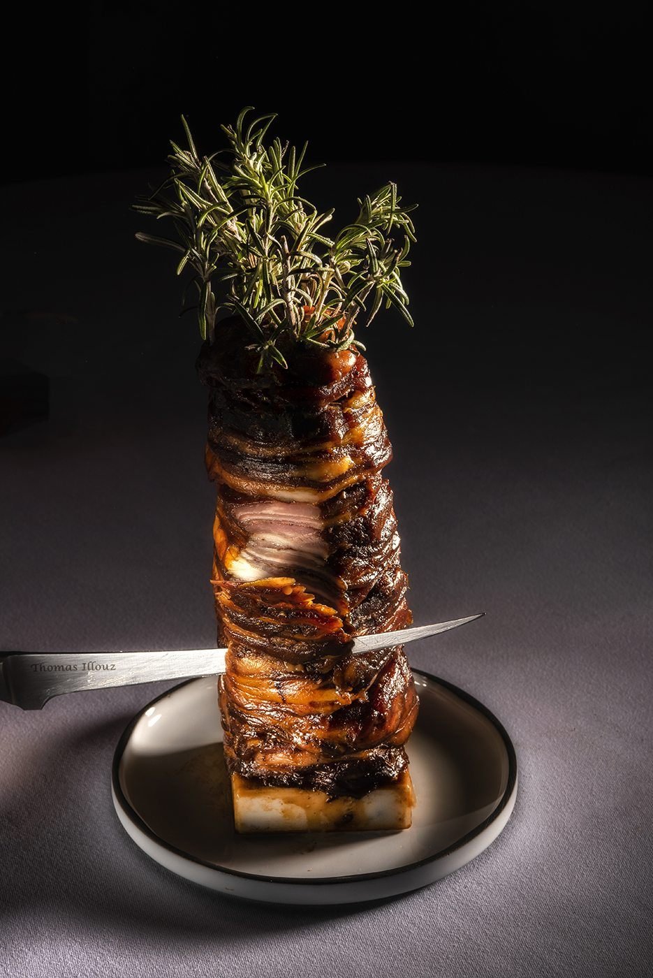 Brochette d'agneau dressée à la verticale, piquée d'une branche de romarin
