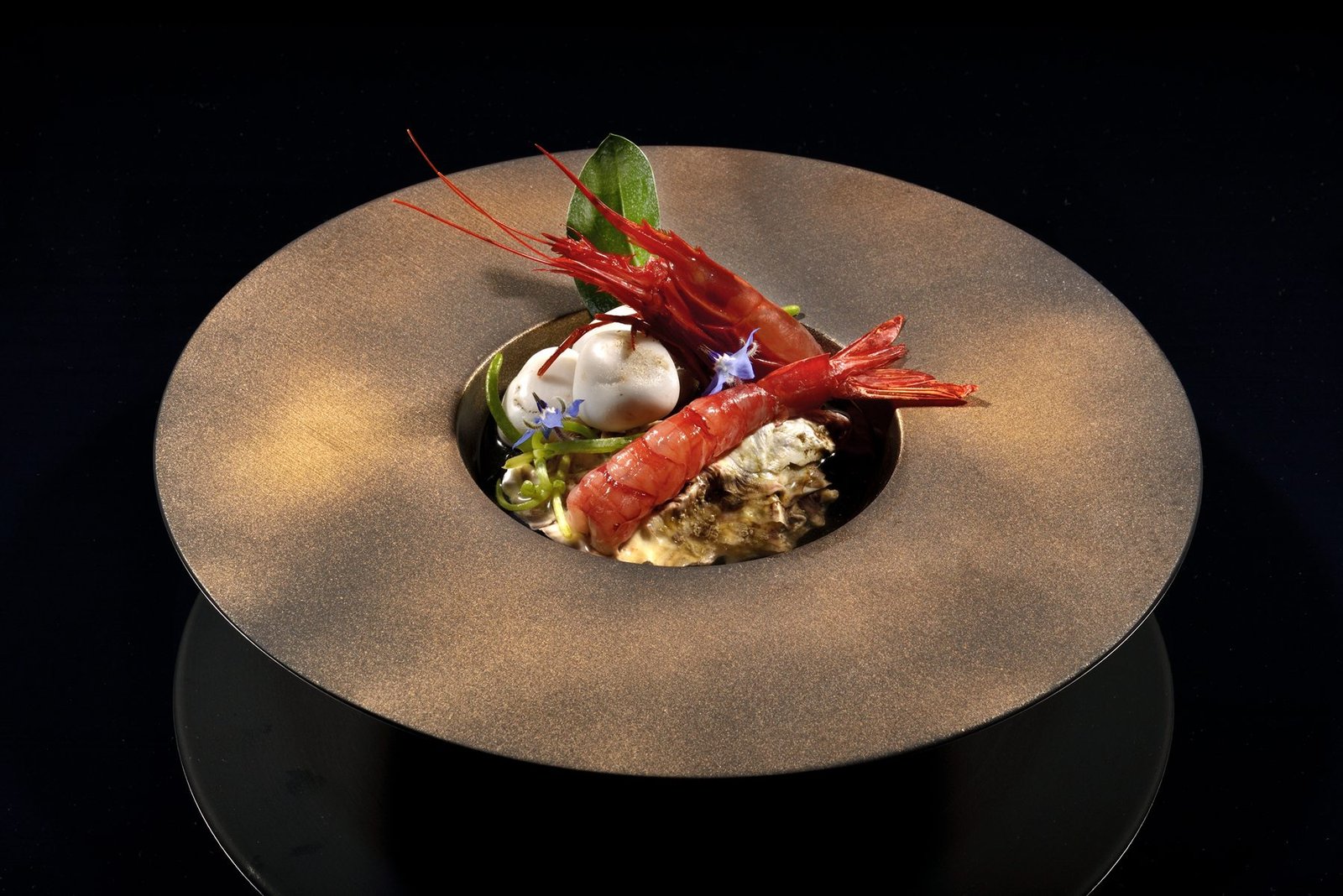 Assiette de porcelaine dorée photographiée sur fond noir